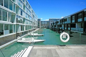 A modern cruise ship with glass railings, a swimming pool, and lifebuoys. - Lighter Quay - Calm & Well-Appointed Pool & Gym (Auckland)