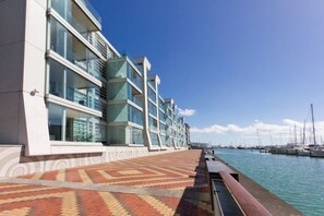 A waterfront hotel with a modern design, featuring a patterned walkway and a marina with boats in the background. - Lighter Quay - Calm & Well-Appointed Pool & Gym (Auckland)