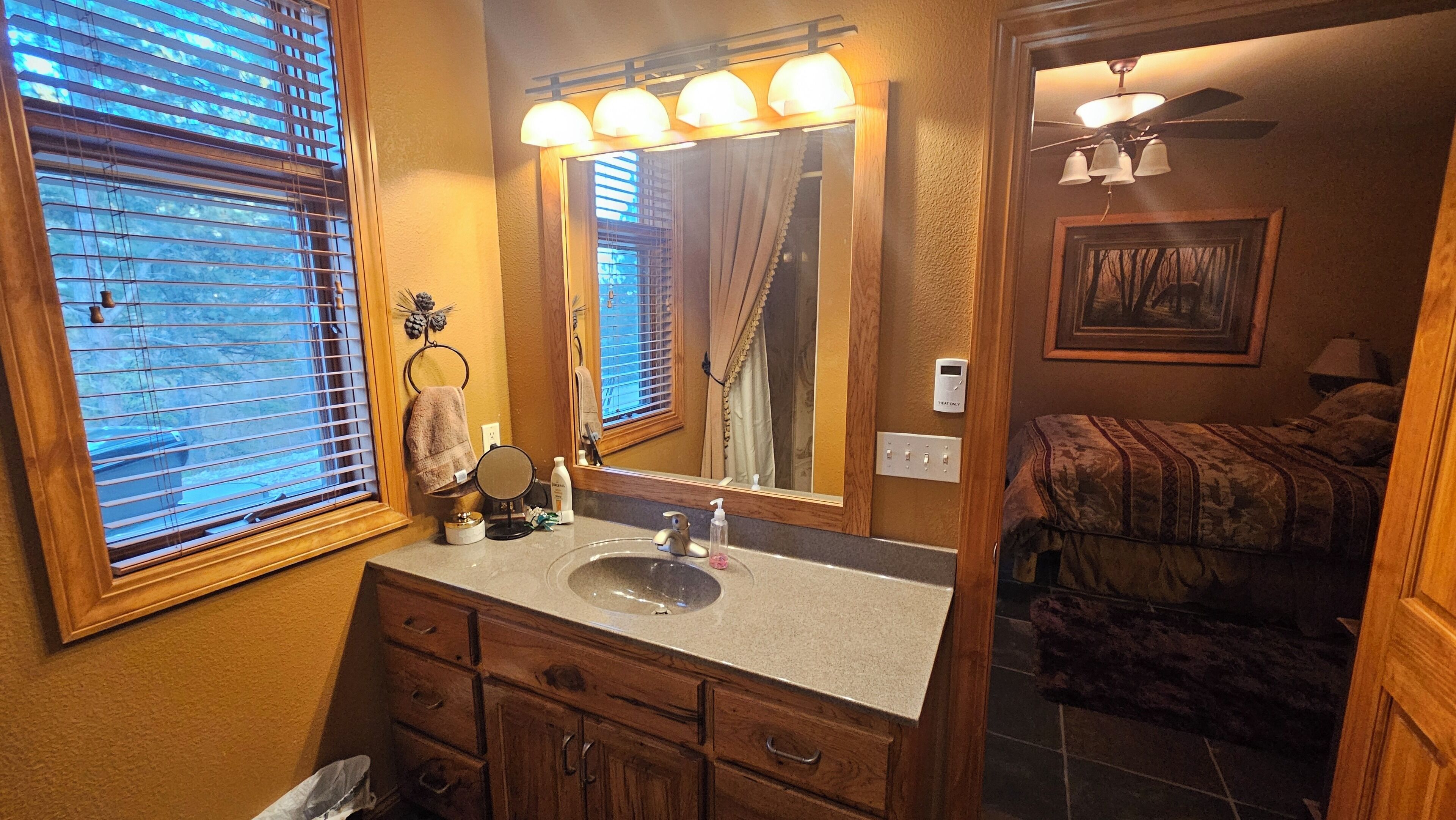 A bathroom with a vanity, sink, mirror, and towel rack.