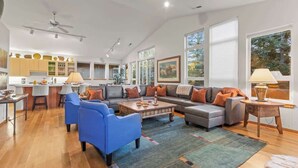 A spacious living area with a sofa, chairs, a coffee table, and a kitchen in the background. - Abode at Sawtooth, chef's kitchen, sleeps 10, near ski resort (Sun Valley)