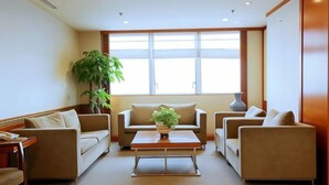 Un salon moderne comprenant un ensemble de canapés, une table basse et une grande fenêtre laissant entrer la lumière naturelle.