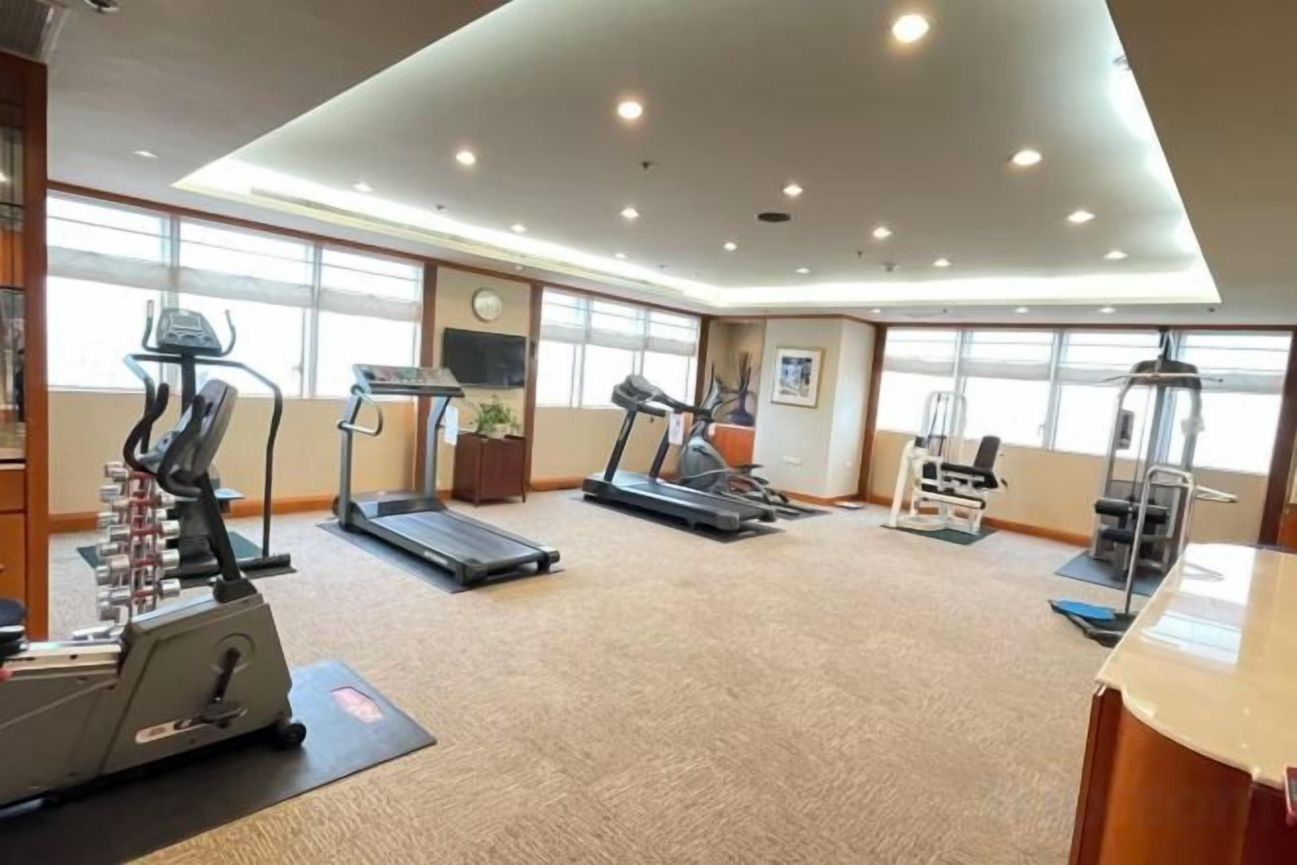 A gym with treadmills, elliptical machines, and weight equipment.