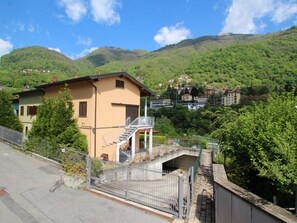 A hillside residential area with a two-story house featuring a balcony and a staircase leading to an upper level. - Borgo Castello by Interhome (Argegno)