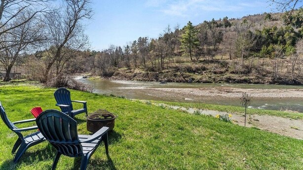 Une vue sur la rivière, avec des places assises en plein air et un foyer.