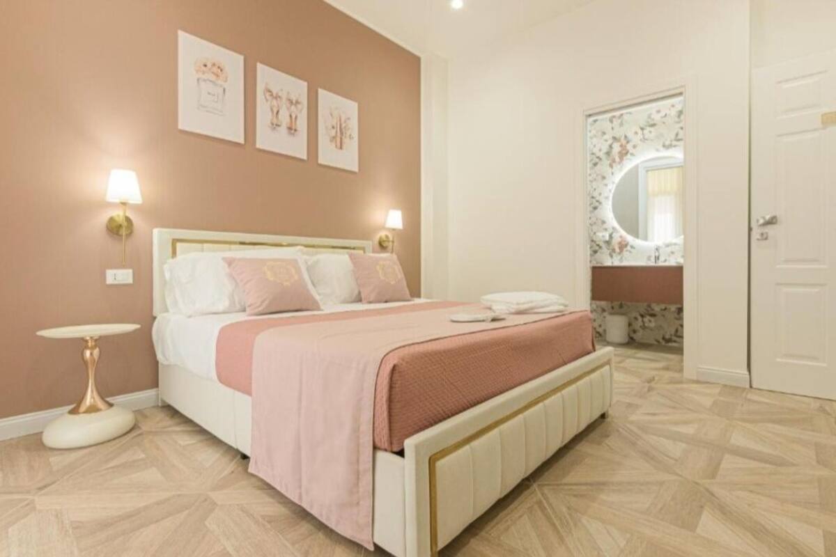 Ein Schlafzimmer mit einem Bett, Nachttischen, einem Spiegel und Bildern an der Wand.