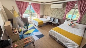 A hotel room with a bed, a desk with a laptop, a chair, a small table with items, and a window with curtains. - TS Hotel (Taitung)