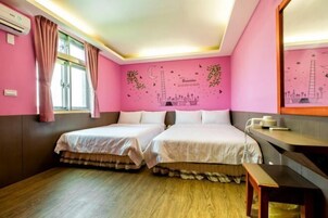 Una habitación con dos camas, un escritorio y una ventana con cortinas.