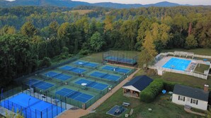 An aerial view of a tennis facility with multiple courts, surrounded by dense forest and hills. - Farlea: Classic Country Charm Minutes from UVA (Charlottesville)