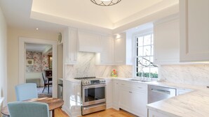 A modern kitchen with white cabinets, a built-in oven, and a large window. - Farlea: Classic Country Charm Minutes from UVA (Charlottesville)