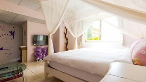A bedroom with a bed, a TV, a glass table, and a window. - Hualien Yi Jing BnB (Hualien)