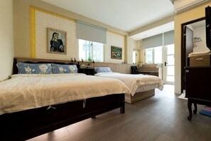 Een slaapkamer met twee bedden, een kaptafel en een raam.