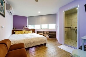 A bedroom with a bed, a sofa, a walk-in closet, and a shower area. - Hualien Yi Jing BnB (Hualien)