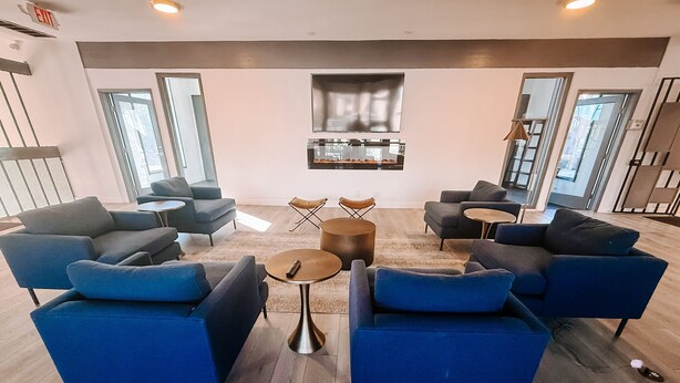 Un'area lounge moderna con divani blu, un piccolo tavolino rotondo e un camino.