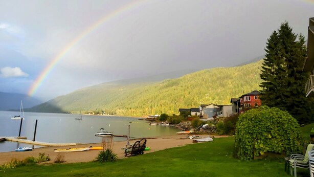 A lakeside view with a rainbow, boats, and houses. - Lakefront Retreat 2 bedroom sleeps 6,  private hot tub and beach. (Nelson)