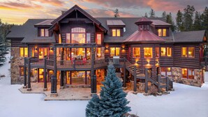 A large, multi-story log cabin with a prominent balcony and a stone foundation. - Fore Seasons Lodge | Pole Creek Golf Course | Private Hot Tub | Sleeps 16! (Tabernash)