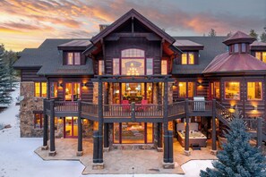 A large, multi-story wooden lodge with a balcony and hot tub, surrounded by snow. - Fore Seasons Lodge | Pole Creek Golf Course | Private Hot Tub | Sleeps 16! (Tabernash)