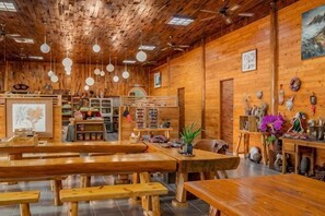 A rustic wooden interior with wooden benches, tables, and hanging light fixtures. - Alishan Sunrise B&B (Chiayi County)