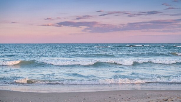 A beach with waves and a clear sky. - Stunning 10th-Floor 1-Bedroom Oceanview Condo (Myrtle Beach)