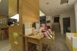 Un interior moderno con un escritorio de madera, libros y una escalera que lleva a otro nivel.
