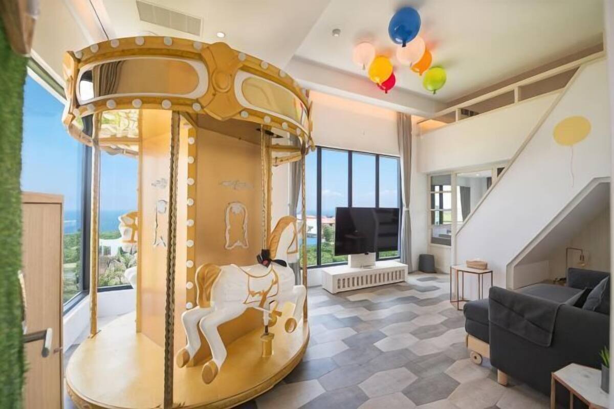 A carousel, a large window, a staircase, and a television.