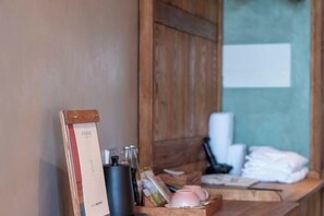 Een houten receptiebalie met een ingelijste certificaat, een zwarte mok en roze bekertjes.