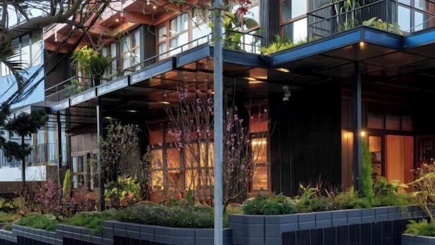 A modern building with a covered outdoor area featuring plants and a balcony. - The Pink Boutique Hotel (Dalat)