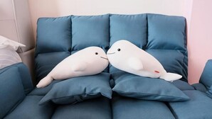 A blue sofa with two white plush toys resembling birds. - Dolphin B&B (Pingtung)