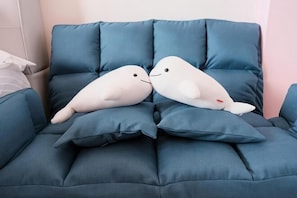 A blue sofa with two white plush toys resembling seals. - Dolphin B&B (Pingtung)