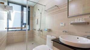 A modern bathroom with a glass shower enclosure, a white sink, and a mirror above it. - Dolphin B&B (Pingtung)
