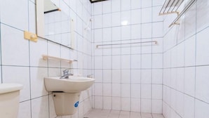 Ein kleines Badezimmer mit Fliesen, einem Waschbecken, einem Spiegel und einem Handtuchhalter.
