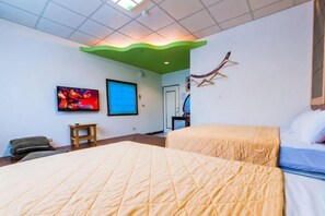 A hotel room with two beds, a television, a small table, and a door. - FONG CAI Hostel (Pingtung)
