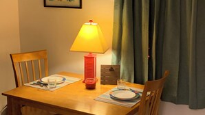 A dining table with chairs, a lamp, and a framed picture on the wall. - Beach Side Studio #2 - Pet Friendly, WiFi, Off-Street Parking, Large Smart TV (Norfolk)