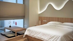 A modern bedroom with a bed, bedside tables, a window with blinds, and a wall-mounted light fixture. - Wuzheng Wood hall (Chiayi County)