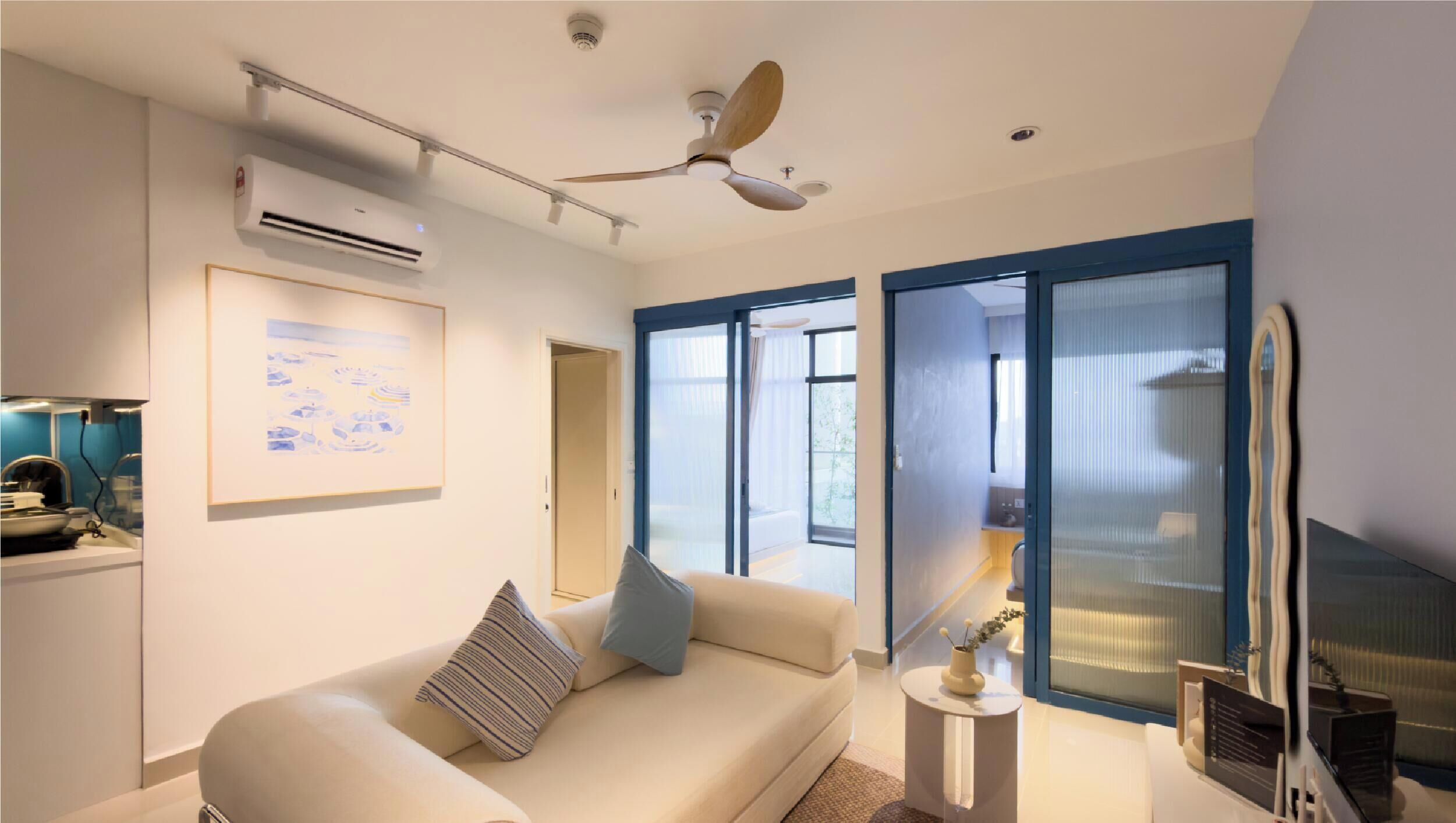 A modern living room with a sofa, a ceiling fan, and a large window.