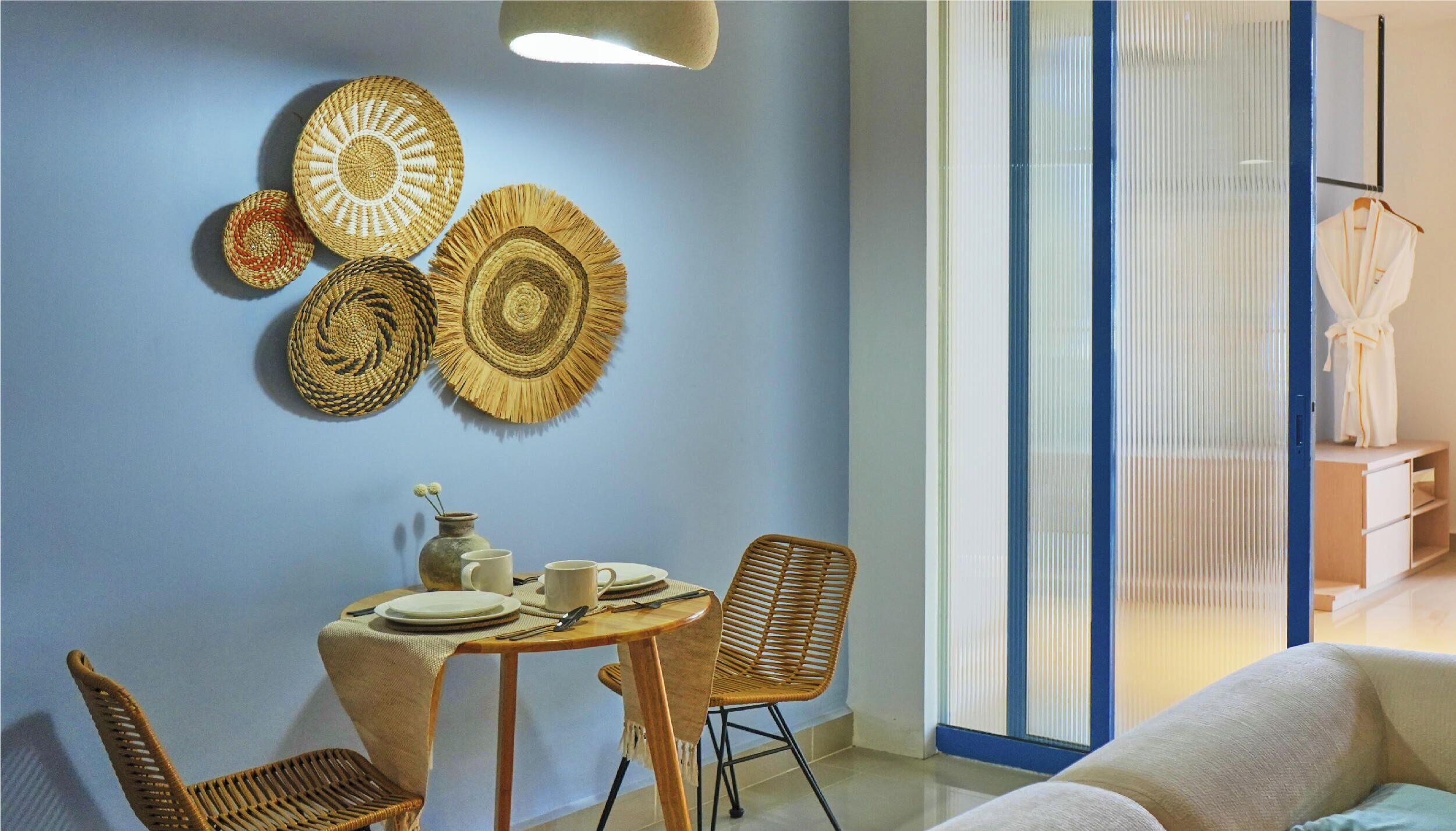 A dining area with a round table, chairs, and wall-mounted woven placemats.