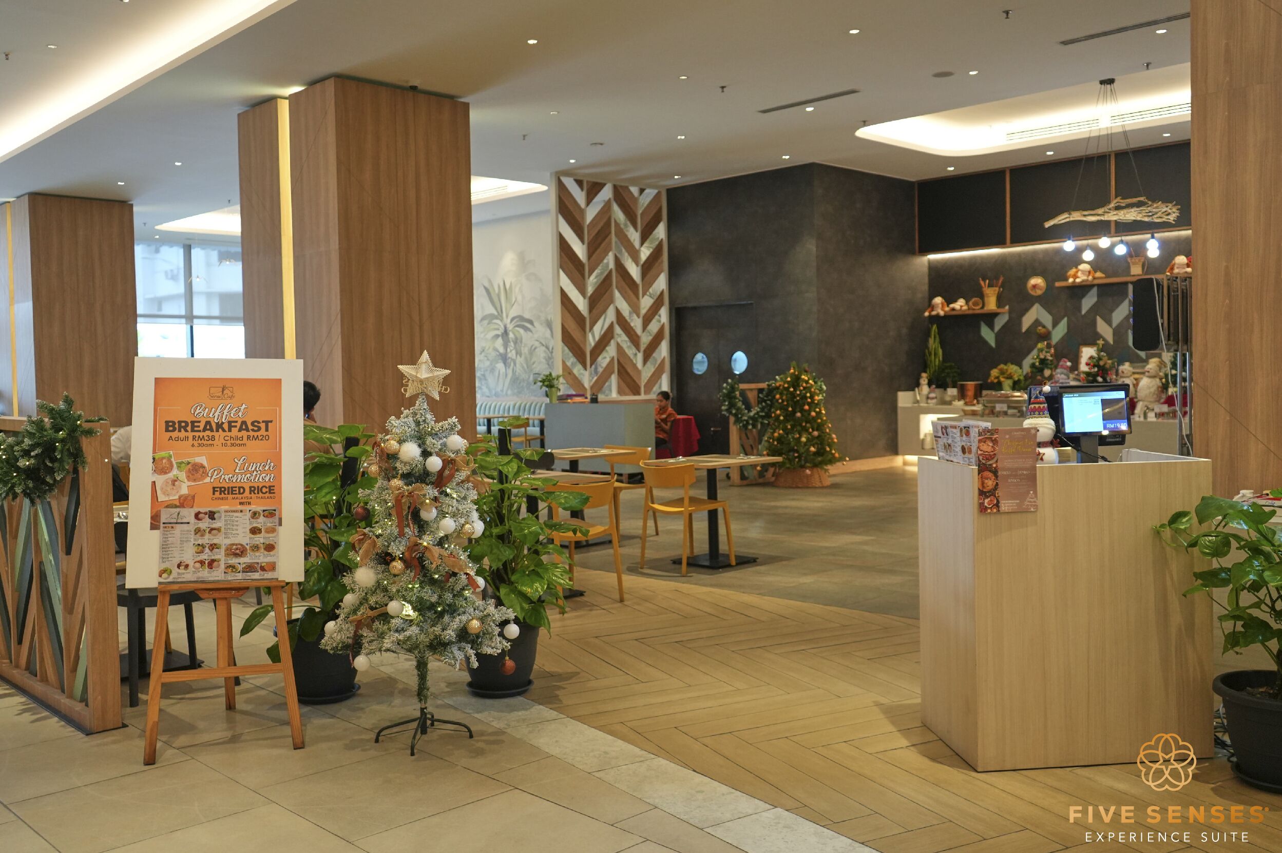 Un moderno vestíbulo de hotel con mostrador de recepción, un árbol de Navidad y un panel de menú.