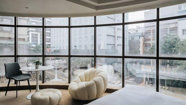 A modern room with large windows, a bed, a round table, and two chairs. - Meworld Hotel-Sanchong (New Taipei City)
