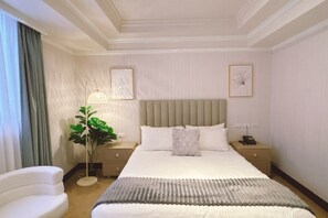 A hotel room with a bed, bedside tables, a lamp, a plant, and artwork on the walls. - Meworld Hotel-Sanchong (New Taipei City)