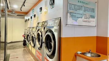 A laundry facility with multiple washing machines and a sink.