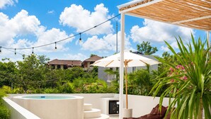 A rooftop pool area with a hot tub, outdoor seating, and string lights. - Okeanos Boutique Hotel Ungasan Uluwatu (Ungasan)