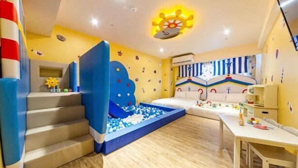 A child's playroom with a slide, ball pit, and a bed. - Toyfun Hotel (Yilan)