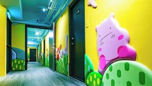 A brightly colored hallway with a playful, cartoonish design on the walls, featuring large, colorful animal shapes. - Toyfun Hotel (Yilan)