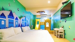 A room with a bed, a small table, and chairs. There are colorful wall decorations and a window. - Toyfun Hotel (Yilan)