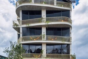 A multi-story building with balconies, large windows, and a curved architectural design. - Phuc Hai Hotel Da Lat (Dalat)