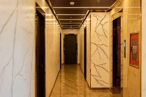A hallway with marble walls and a polished floor, leading to a door with a sign. - Phuc Hai Hotel Da Lat (Dalat)