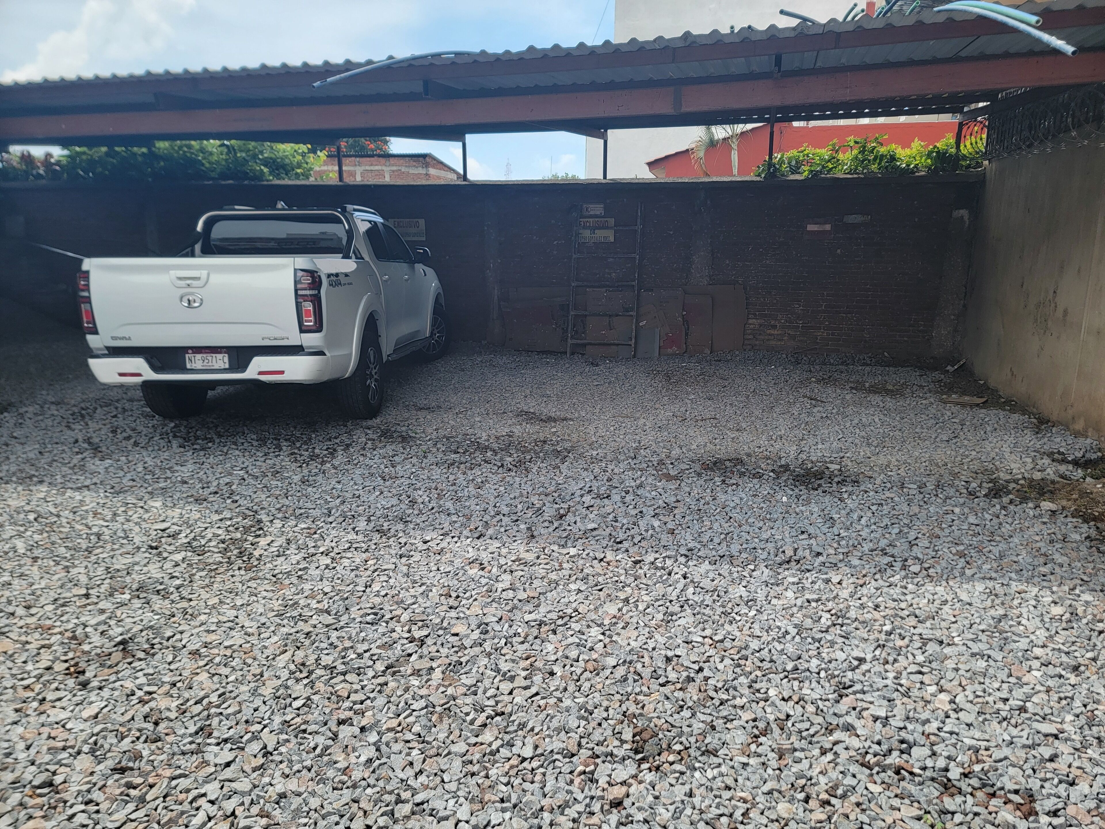 Un camionnette blanche était garée sur une allée gravillonnée.