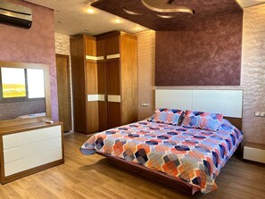 A bedroom with a bed, a dresser, a wardrobe, and a television. - Luxury apartment by the sea (Martil)