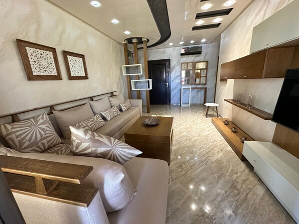 A modern living room with a sofa, coffee table, and TV stand. - Luxury apartment by the sea (Martil)