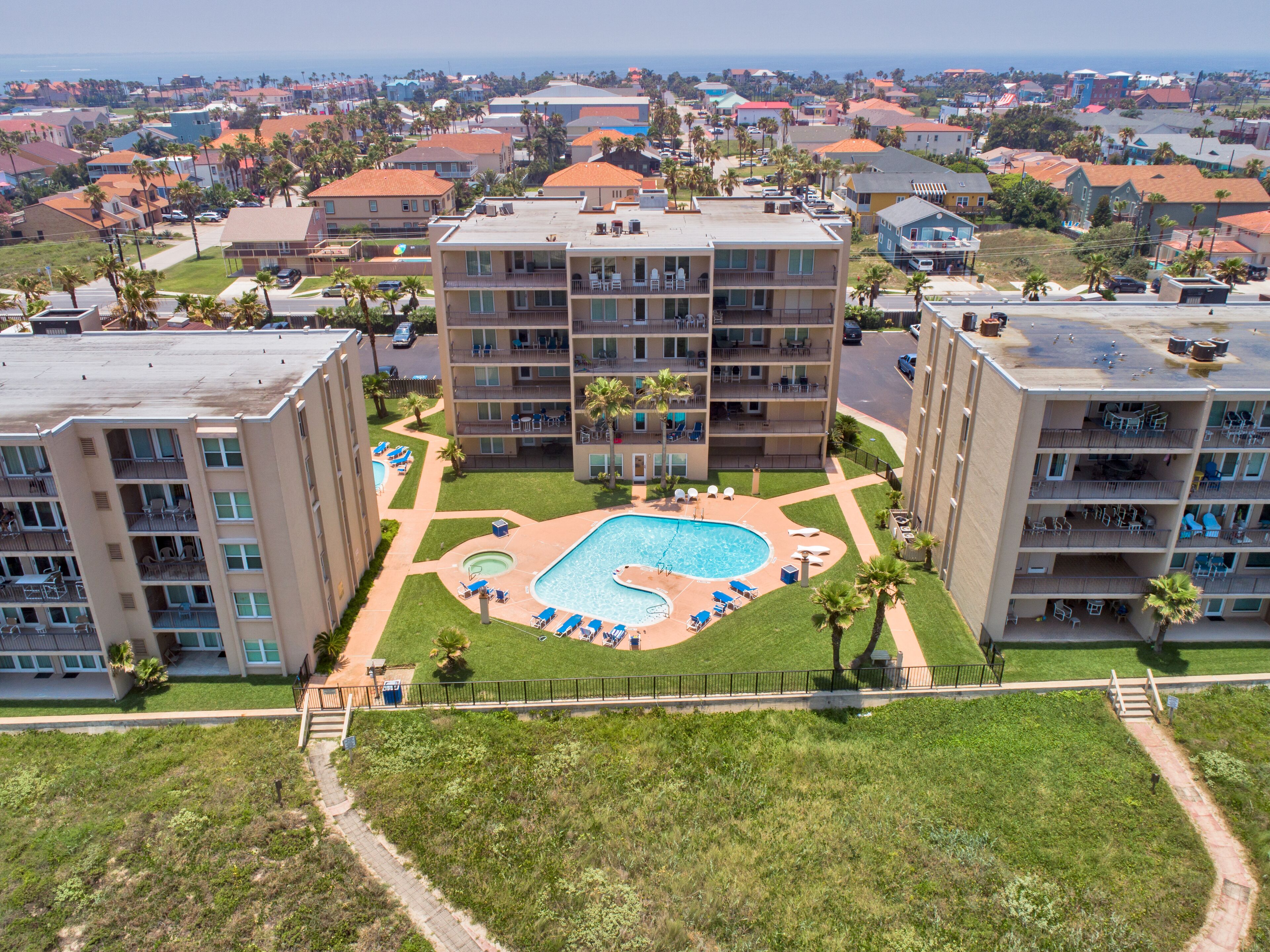 Ein Hochhotel mit Pool auf dem Dach, mehreren Balkonen und Blick auf die umliegende Gegend.