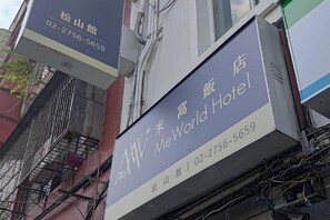 A hotel sign with the name 'MeWorld Hotel' and a phone number.